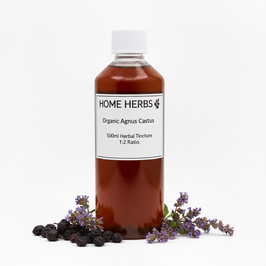 A 500ml bottle of Home Herbs Organic Agnus Castus herbal tincture, filled with amber-brown liquid and topped with a white cap, displayed on a white background with dried agnus castus berries and purple flowers at its base.