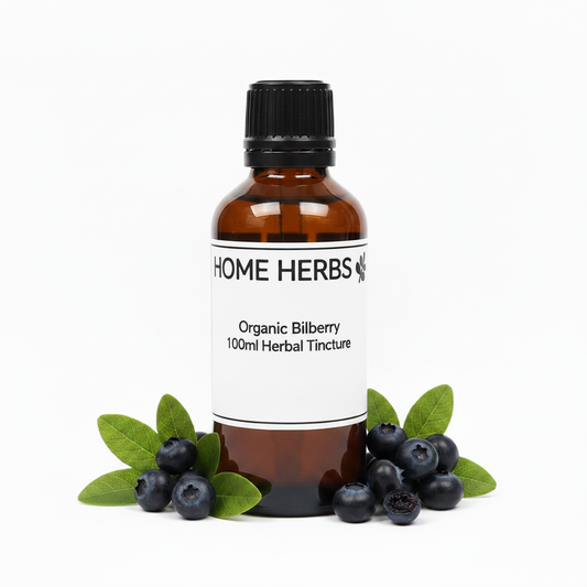 An amber glass bottle of Home Herbs Organic Bilberry 100ml Herbal Tincture with a black cap and white label, styled with fresh green bilberry leaves and blueberries on a white background.