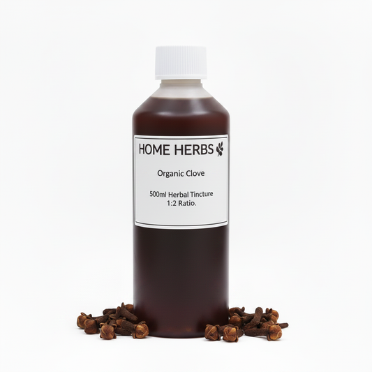 A 500ml bottle of Home Herbs Organic Clove Herbal Tincture, 1:2 ratio, filled with dark amber liquid and topped with a white cap, displayed on a white background with cloves scattered at its base.