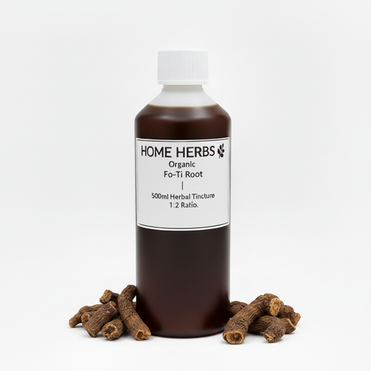 A 500ml amber glass bottle of Home Herbs Organic Fo-Ti Root herbal tincture, displayed on a white background with several dried root pieces arranged at its base.