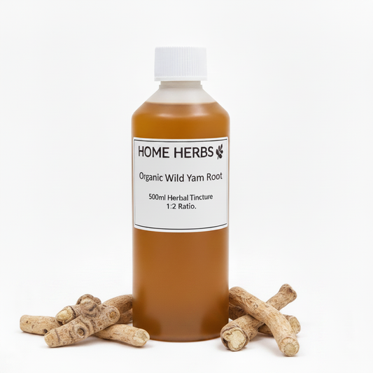 A 500ml bottle of Home Herbs Organic Wild Yam Root herbal tincture, filled with an amber-brown liquid and topped with a white cap, displayed on a white background with several raw root pieces arranged at its base.